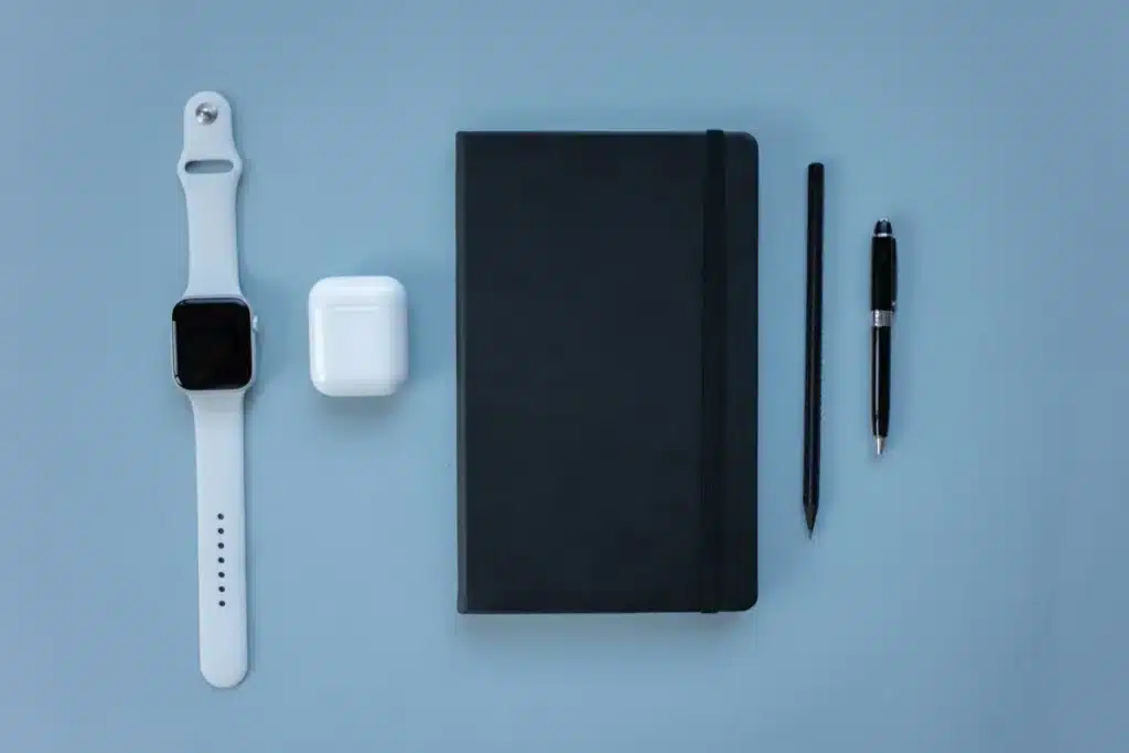 Des écouteurs sans fil compacts posés sur un espace de travail technologique épuré avec éclairage doux