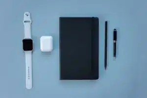 Des écouteurs sans fil compacts posés sur un espace de travail technologique épuré avec éclairage doux