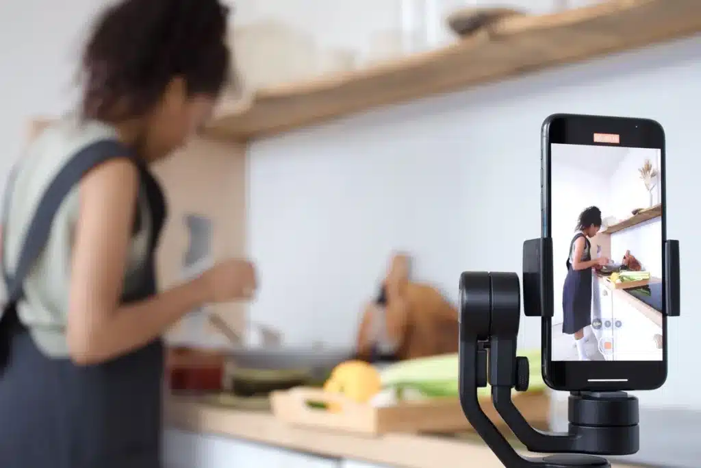 Mains tenant une petite caméra gimbal stabilisée lors d'une prise de vue en extérieur