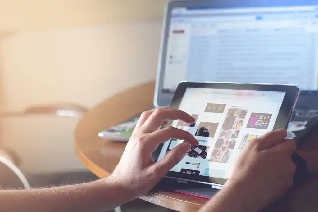 Main de personne tenant un boîtier de streaming compact devant un téléviseur