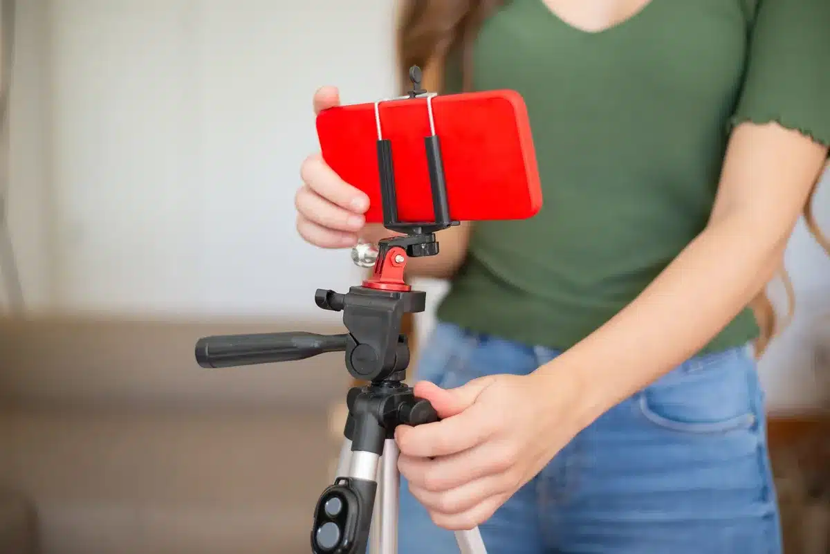 Créateur de contenu filmant en extérieur avec une caméra compacte en main levée