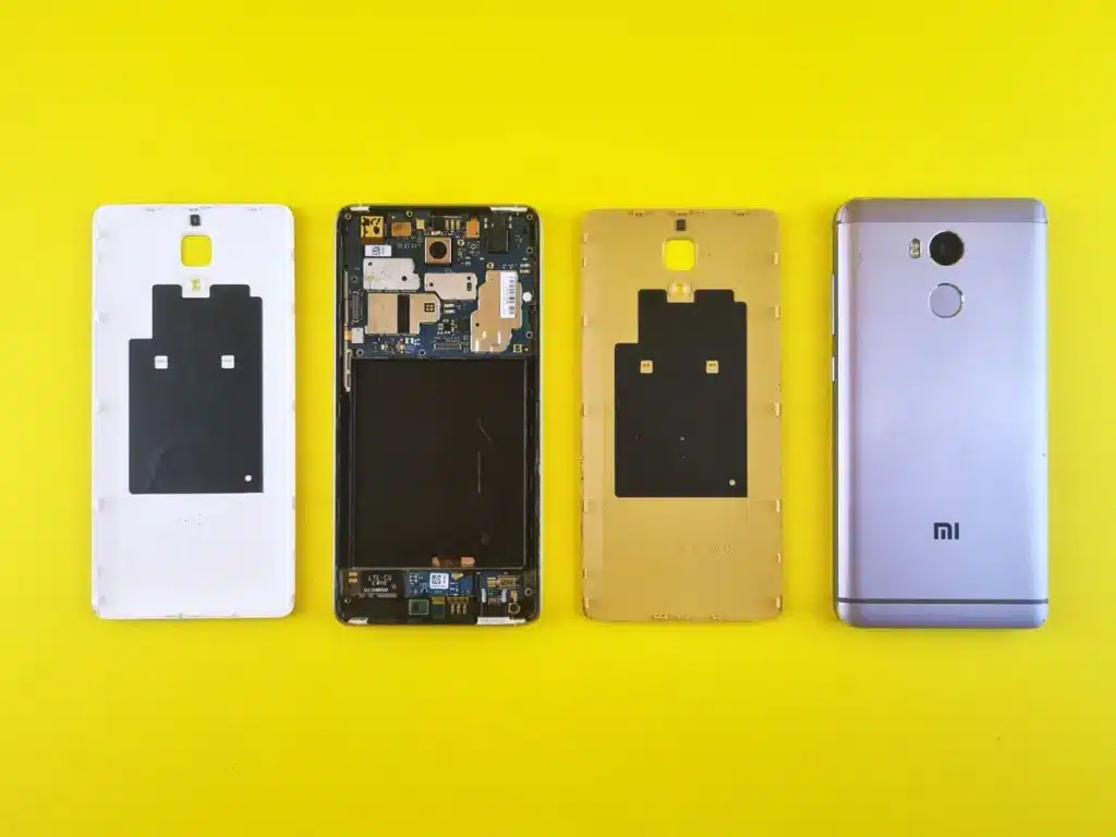 Mains ouvrant un smartphone modulaire avec pièces remplaçables et outils de réparation sur un établi