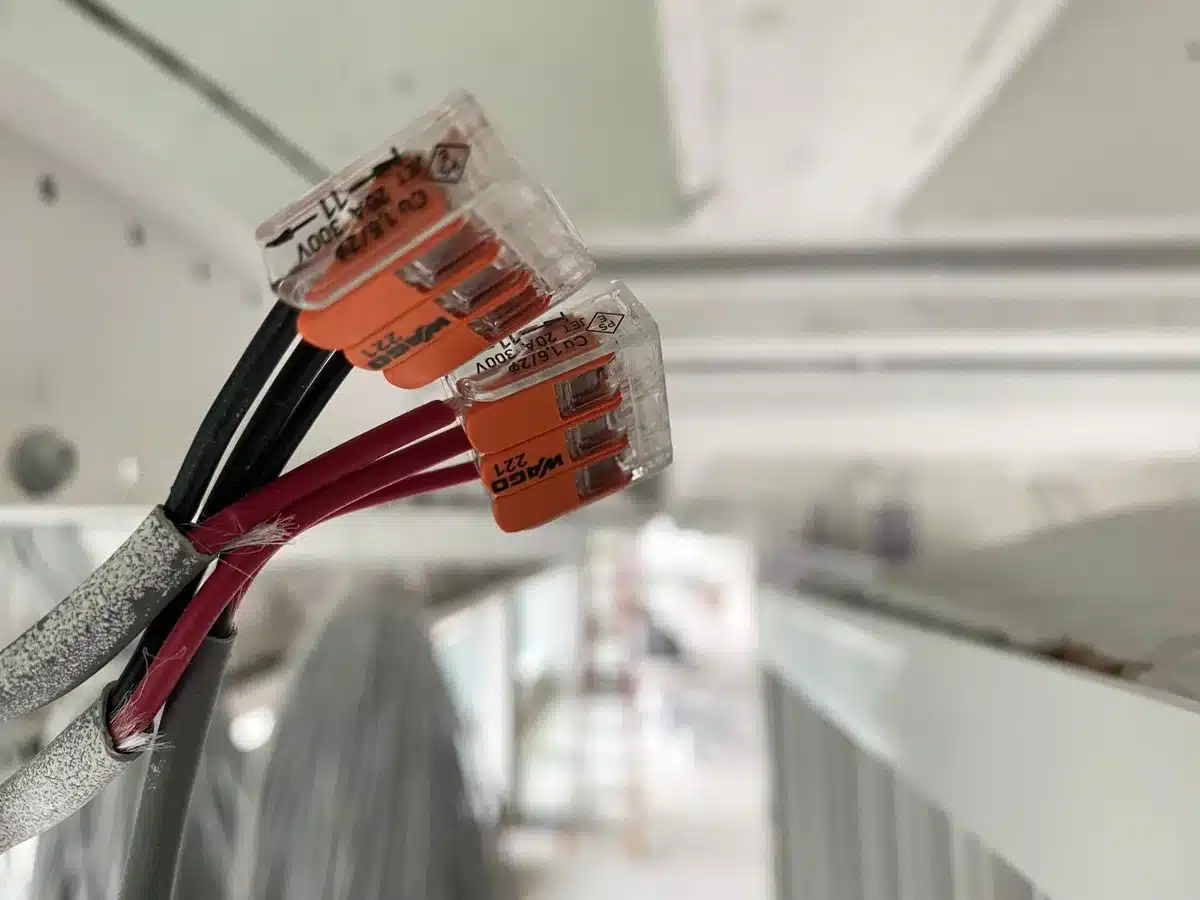 Sonnette vidéo connectée câblée montée sur un encadrement de porte avec câblage visible
