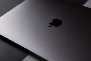 Mains tapant sur un clavier Mac avec une icône de sécurité sur l'écran en arrière-plan