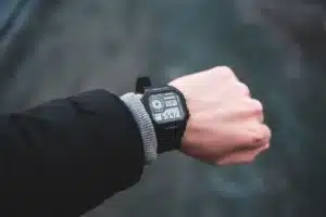 Montre de sport solaire portée au poignet sous la lumière du soleil près de l'eau