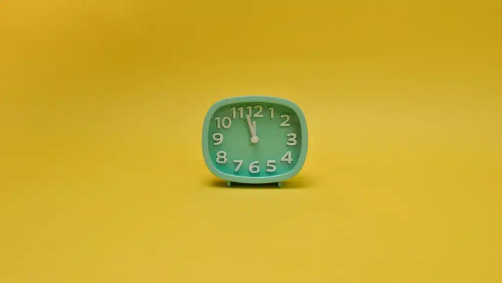 Réveil connecté circulaire sur une table de chevet avec affichage de l'heure et de la météo dans une chambre