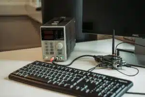 Ordinateur portable et écran de bureau affichant du code et des processus d'IA dans un espace de travail technique