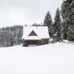 Paysage enneigé hivernal doux et réconfortant avec lumière chaleureuse au loin