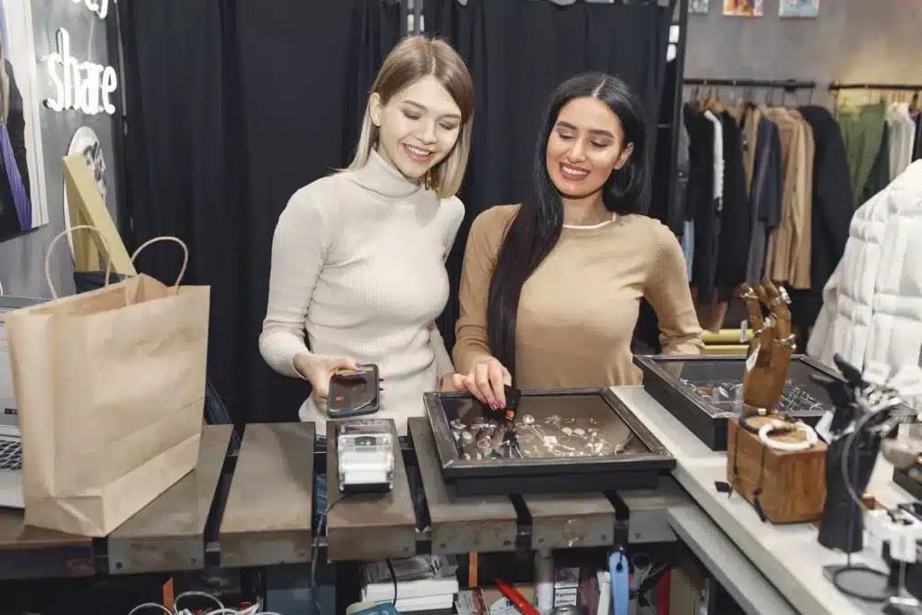 Mains échangeant un smartphone sur un comptoir de vente, avec un autre appareil en arrière-plan