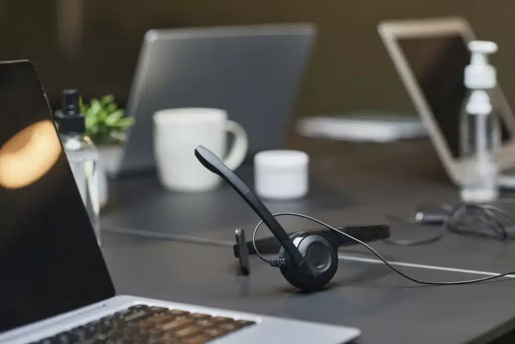 Casque audio posé sur un bureau avec un ordinateur portable et une tasse de café