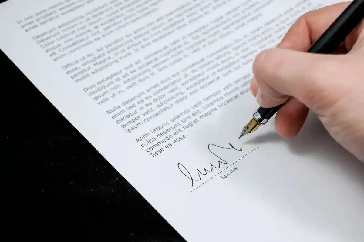 Personne écrivant un article avec des sources et des références visibles sur le bureau