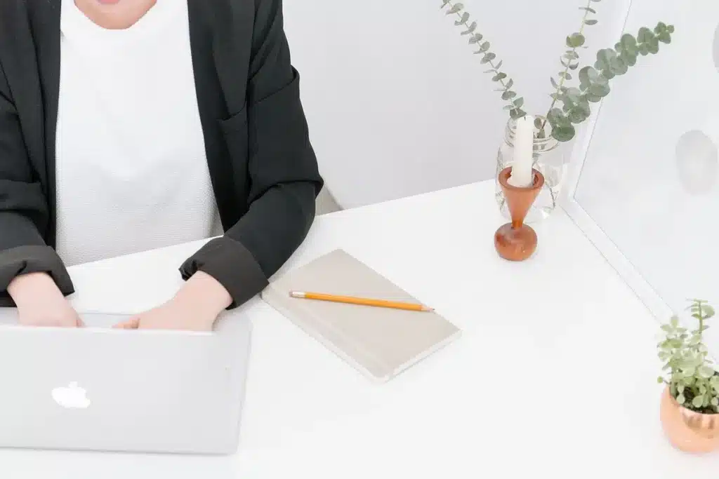 Bureau en lumière du jour avec un ordinateur portable, un carnet de notes et une tasse de café