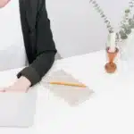 Bureau en lumière du jour avec un ordinateur portable, un carnet de notes et une tasse de café