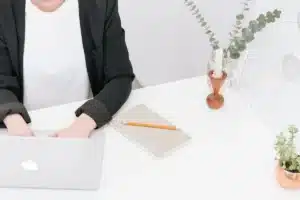 Bureau en lumière du jour avec un ordinateur portable, un carnet de notes et une tasse de café