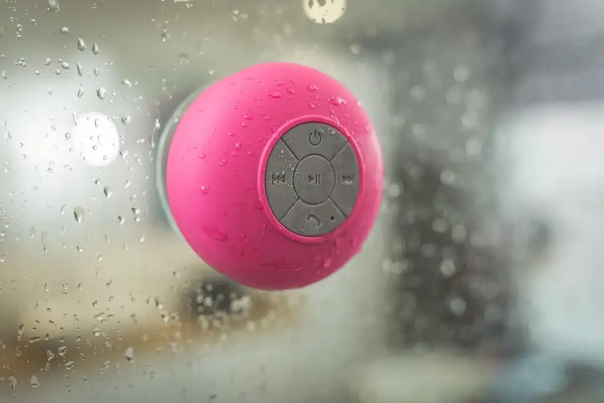 Enceinte étanche IP68 en contact avec l'eau et le sable, démontrant sa résistance