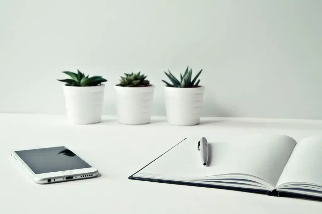 Écouteurs open-ear posés sur un bureau minimaliste à côté d'un téléphone