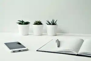Écouteurs open-ear posés sur un bureau minimaliste à côté d'un téléphone