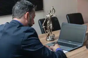 Pile de documents juridiques et contrats éparpillés sur un bureau dans une ambiance sombre
