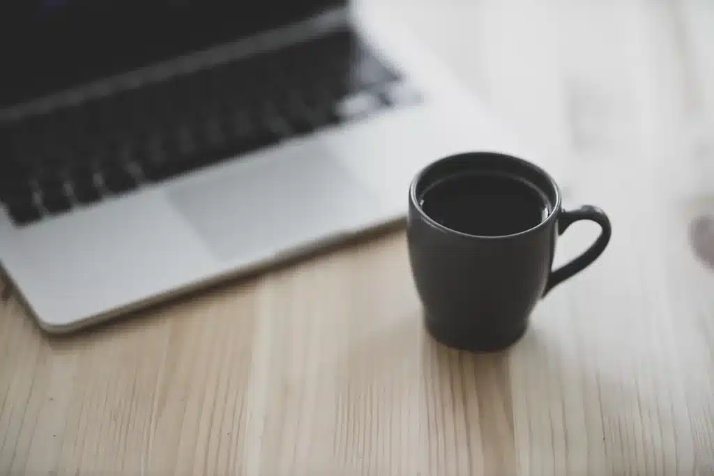 Ordinateur portable montrant une page de blog floue avec mains anonymes au clavier