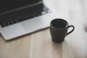 Ordinateur portable montrant une page de blog floue avec mains anonymes au clavier