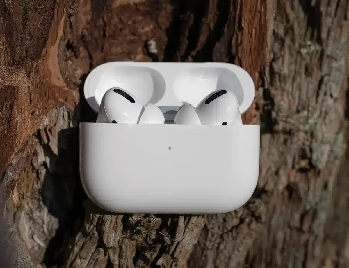Écouteurs sans fil blancs avec étui de charge ouvert sur une surface