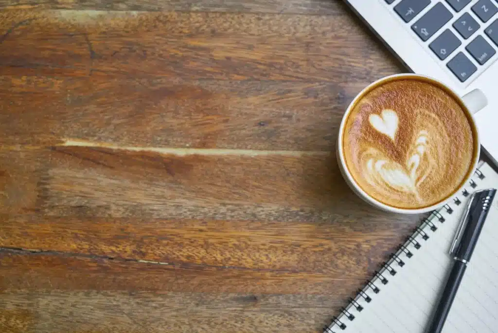 Deux écouteurs sans fil et un iPhone posés sur une table de café en pleine journée
