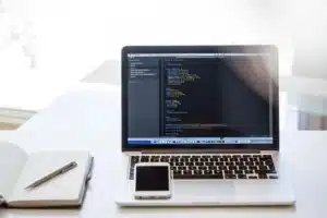 Smartphone posé sur un rebord de fenêtre avec carnet et stylet, usage en journée