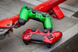 Mains anonymes tenant une manette de jeu devant un univers numérique luminescent et montagneux