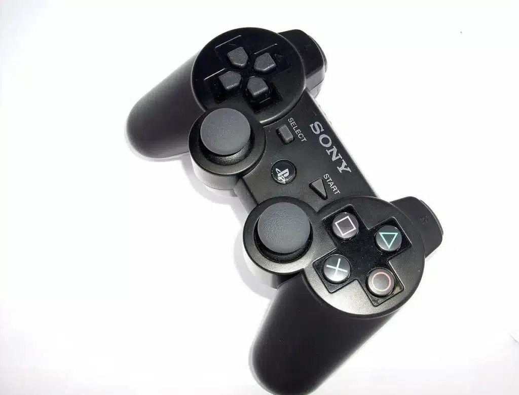 Écouteurs gaming et manette posés sur un bureau en journée