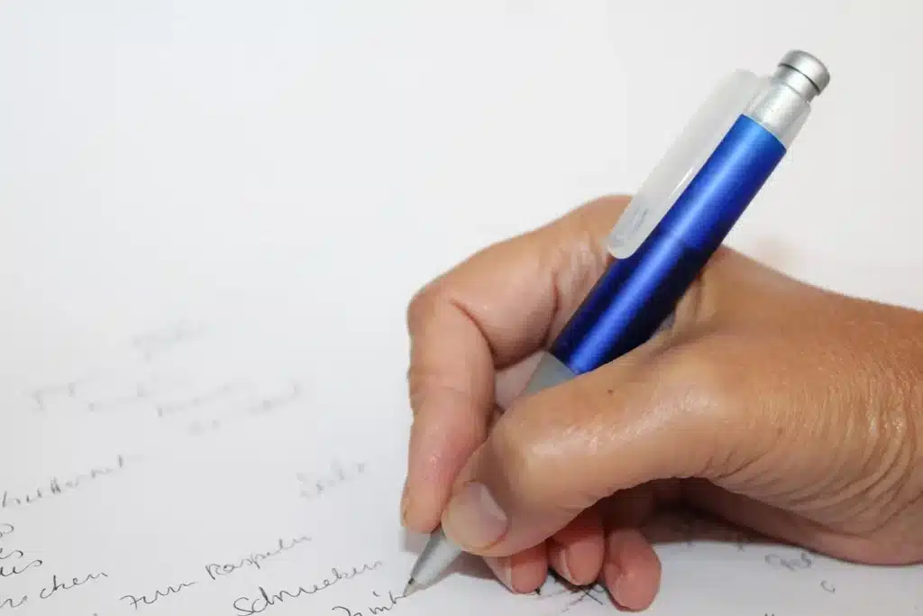 Écouteurs IA pour transcription posés près d'un bloc-notes et d'un stylo sur un bureau