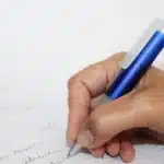 Écouteurs IA pour transcription posés près d'un bloc-notes et d'un stylo sur un bureau