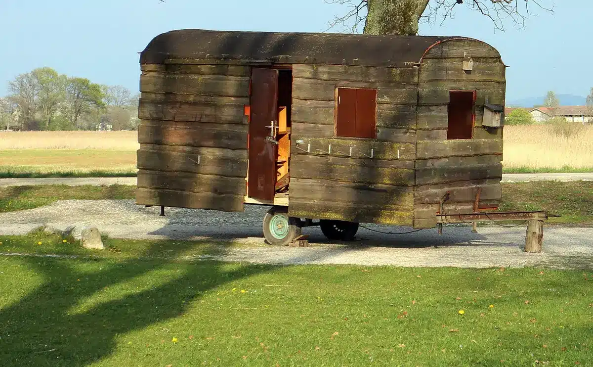 Two anonymous modular camper cubes side by side inside a bright empty van interior, natural daylight, neat wooden surfaces