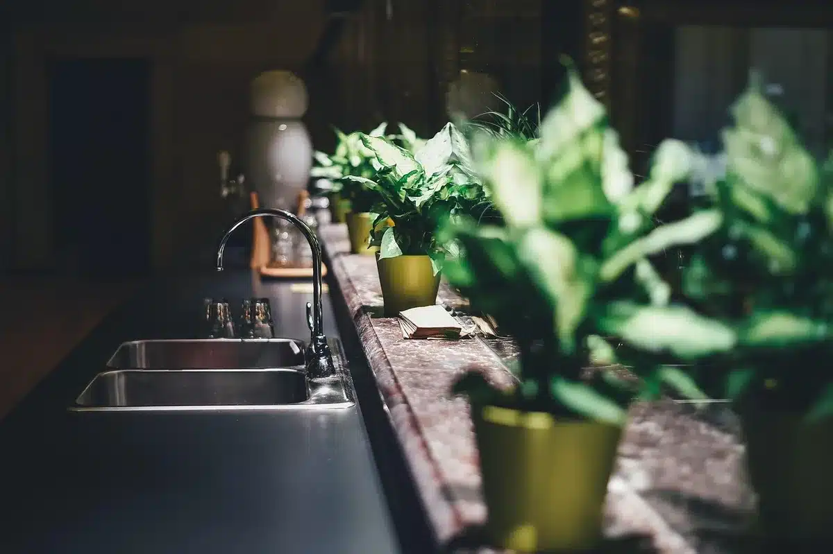 hands using an unbranded smart display on a kitchen table with recipe on screen and utensils nearby