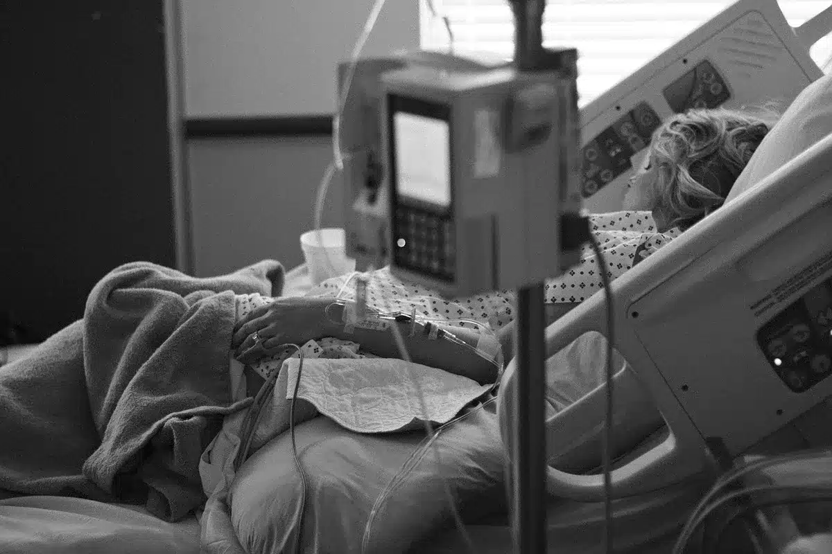 Patient allongé en salle de réveil portant un casque antibruit