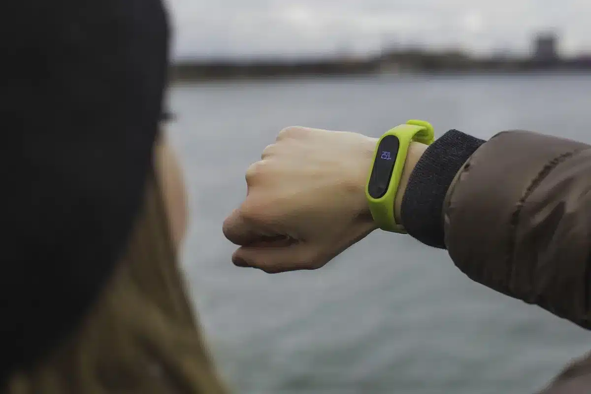 Gros plan d'un poignet portant un tracker montrant des capteurs de fréquence cardiaque