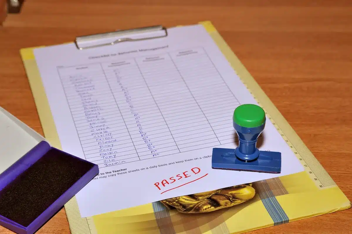 desktop with risk assessment checklist, anonymous hands pointing at printed matrix