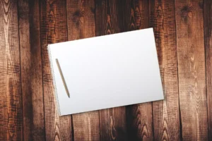 Mains d'ingénieur sur une table lumineuse avec carnet et prototype flou en arrière-plan