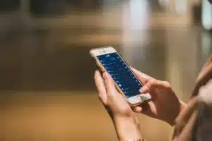 Couloir lumineux avec porte d'entrée, serrure connectée et smartphone affichant une application