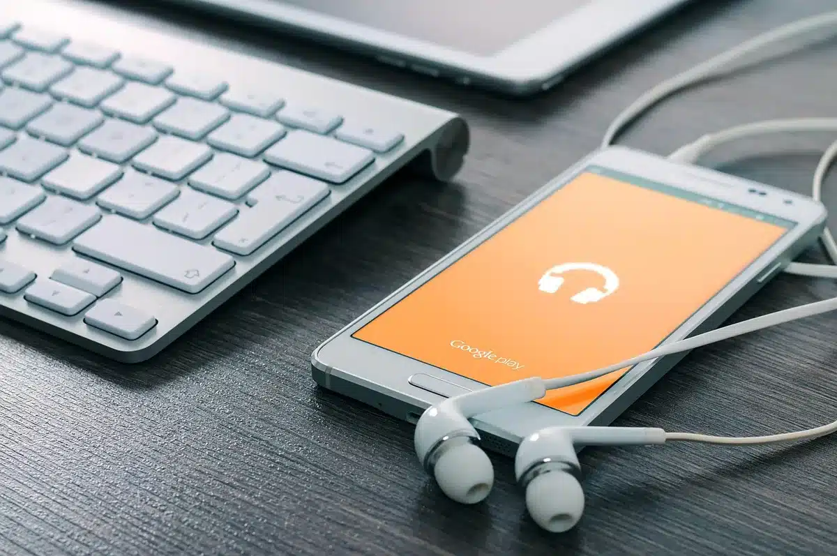 Personne préparant une précommande depuis un smartphone posé sur un bureau lumineux