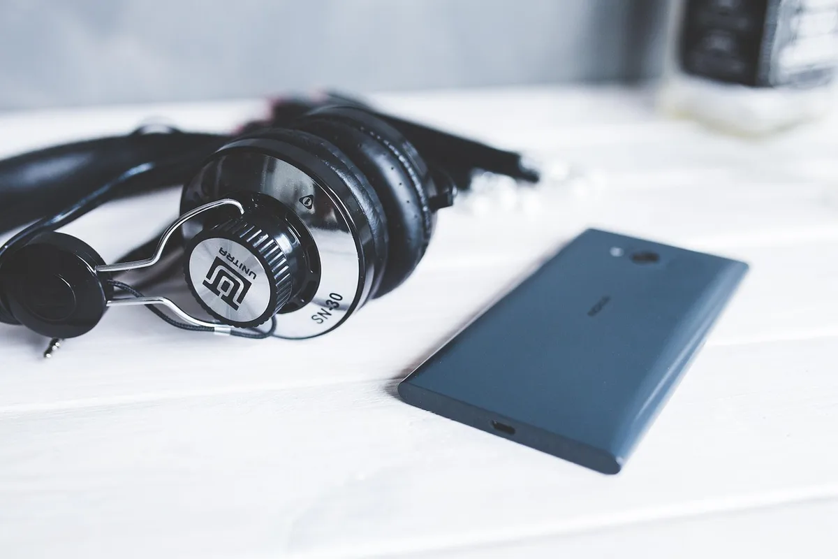Détail d'un casque circum-aural posé près de documents techniques