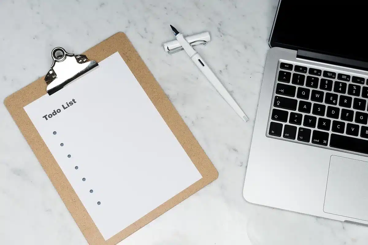 clean desk with a laptop showing Windows settings and hands pointing at task scheduler